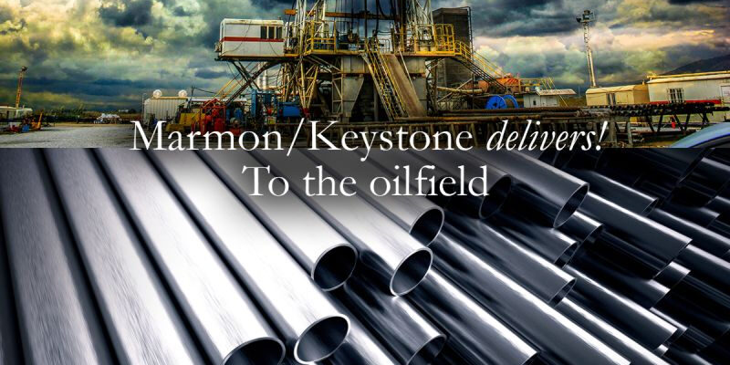 post-1-10 Marmon Keystone Rows of metal pipes are shown in the foreground with an oil drilling rig under a cloudy sky in the background. Text over the image reads, "Marmon/Keystone delivers! Your trusted metals distributor to the oilfield.